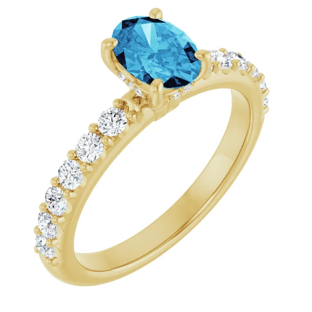 Gold ring with a blue gemstone and smaller diamonds on a white background